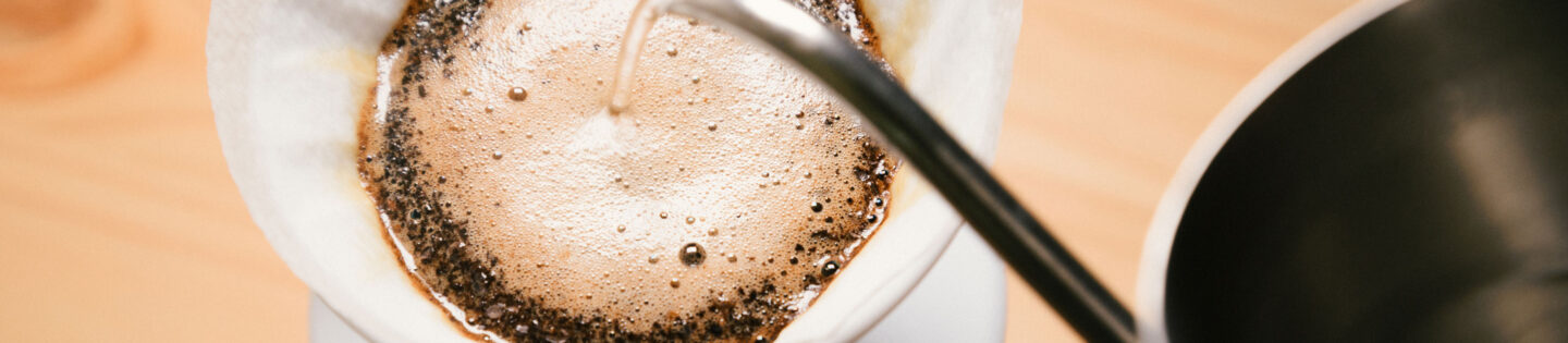 pouring water onto coffee grounds in filter