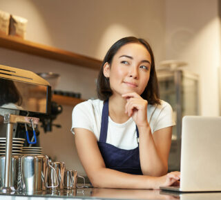 barista with laptop looking curious and thinking