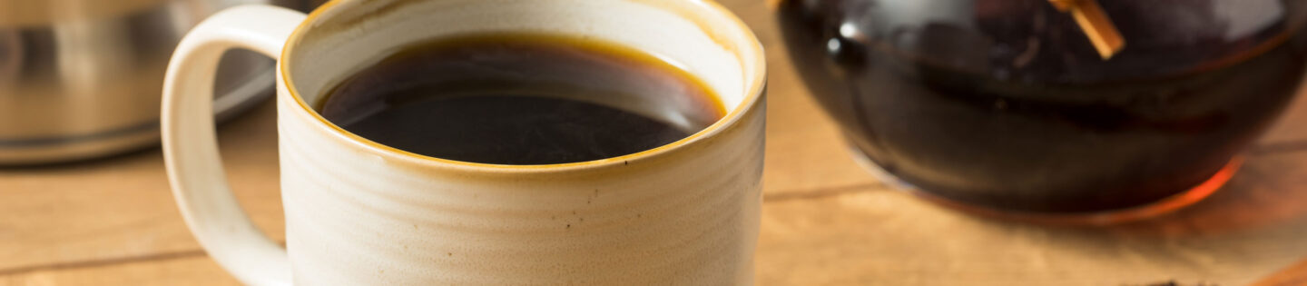 closeup of mug with pour over maker in background