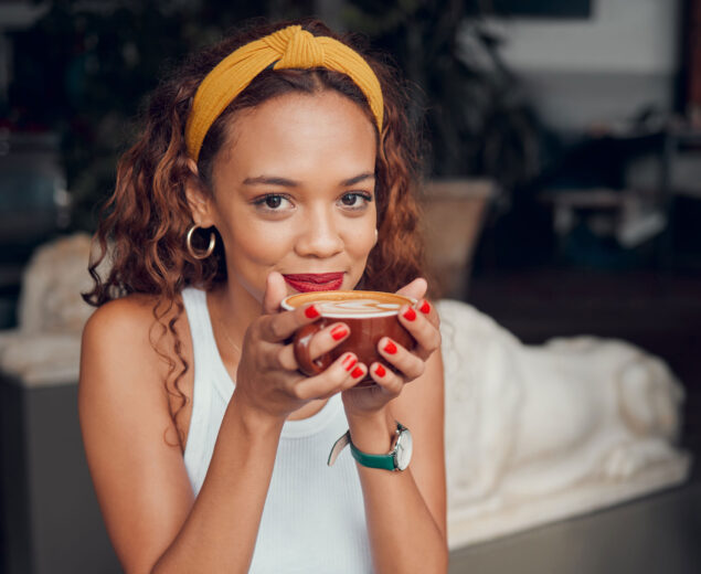 woman drinking coffee looking at camera