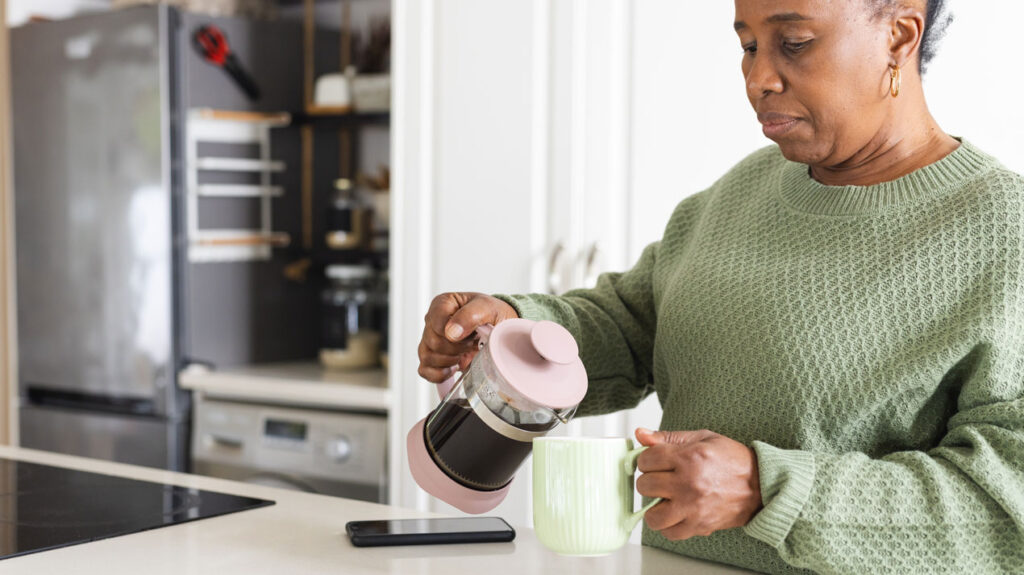 woman pours French press coffee